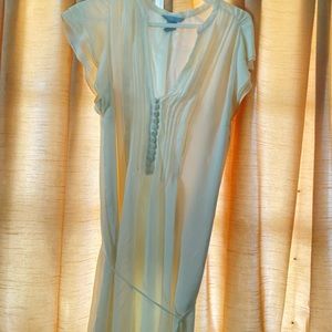 Polyester. White dress. Doesn’t stretch. Has a tie around waist.